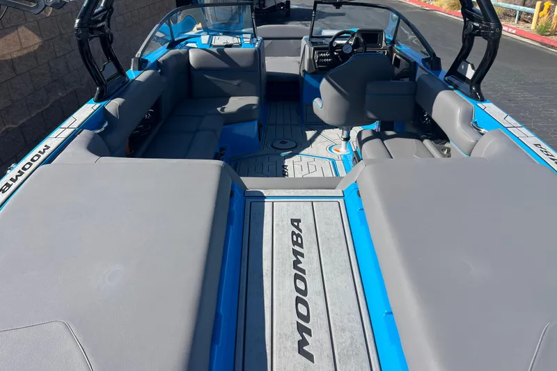Slide: The Image of 2022 Moomba Kaiyen boat interior with gray seating and blue accents. - 13