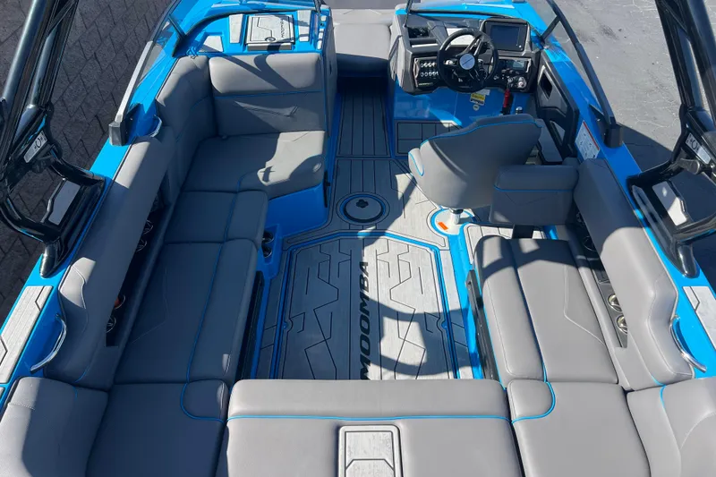 Slide: The Image of 2022 Moomba Kaiyen boat interior with blue accents and spacious seating. - 15