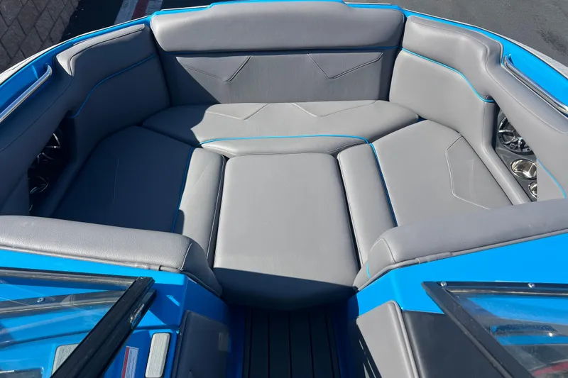 Slide: The Image of 2022 Moomba Kaiyen boat interior with gray seating and blue accents. - 19