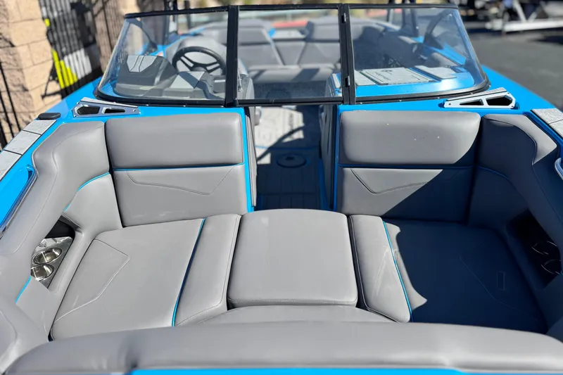 Slide: The Image of 2022 Moomba Kaiyen boat with blue exterior, parked outdoors near mountains. - 2