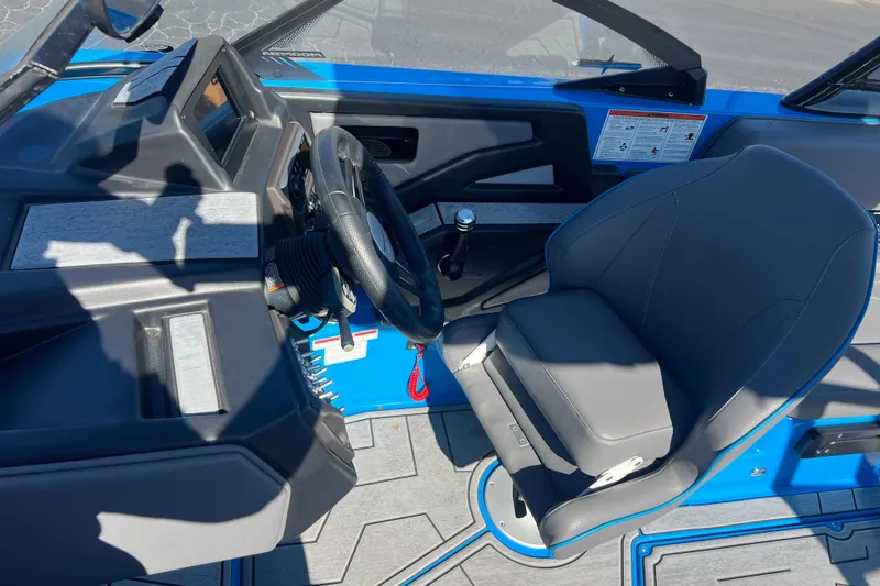 Slide: The Image of 2022 Moomba Kaiyen boat interior with gray and blue seating, cup holders, and speaker. - 20