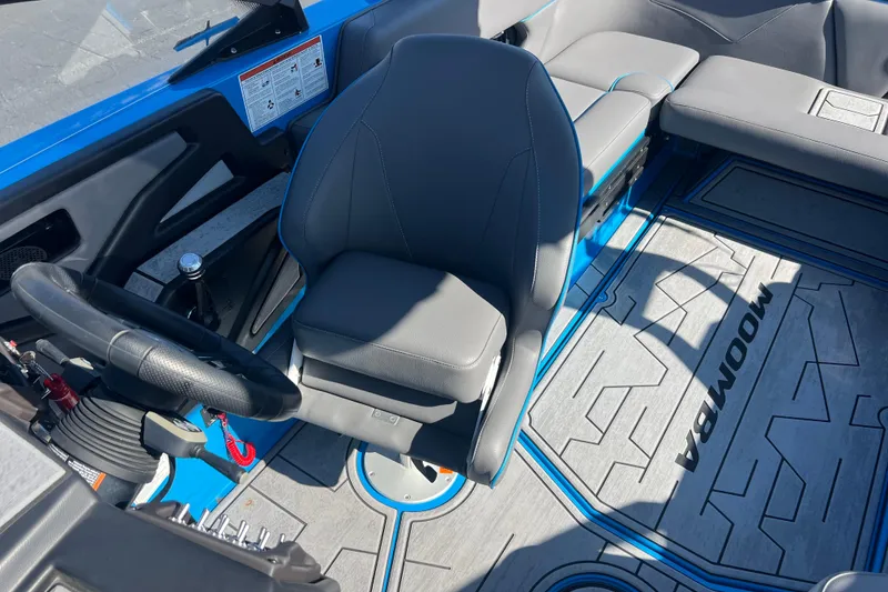 Slide: The Image of 2022 Moomba Kaiyen boat interior with gray upholstery and blue accents. - 21