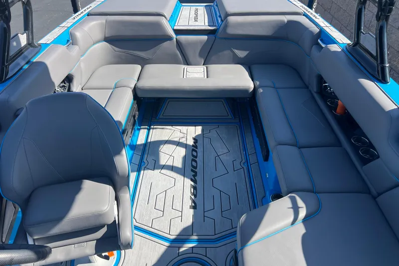 Slide: The Image of 2022 Moomba Kaiyen boat interior with gray seating and blue accents. - 22