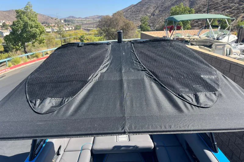 Slide: The Image of 2022 Moomba Kaiyen interior with speaker and cup holders, featuring gray upholstery and blue accents. - 40