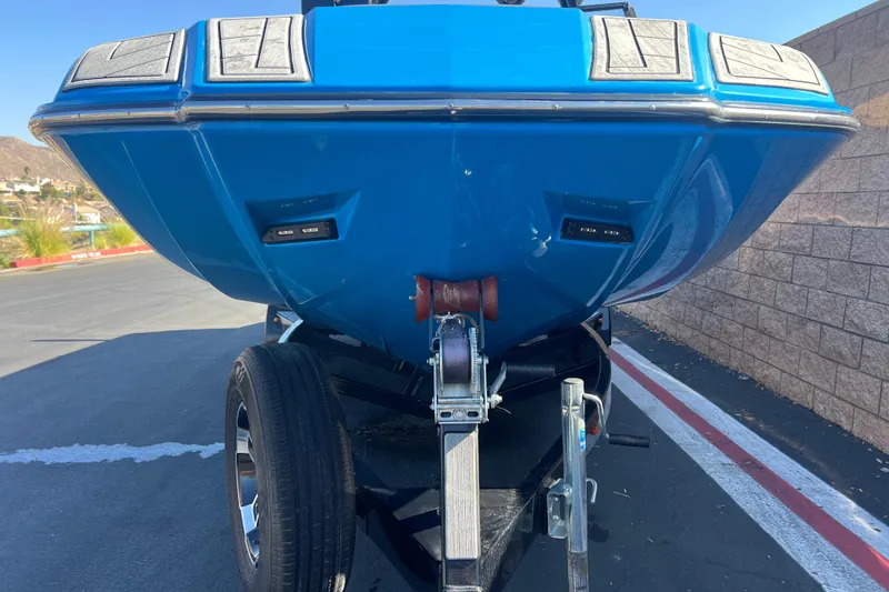 Slide: The Image of 2022 Moomba Kaiyen boat, blue exterior, rear view with seating and branding. - 6