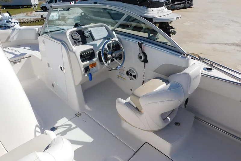 Slide: The Image of 2014 Robalo R207 Dual Console boat interior with steering wheel and controls. - 11