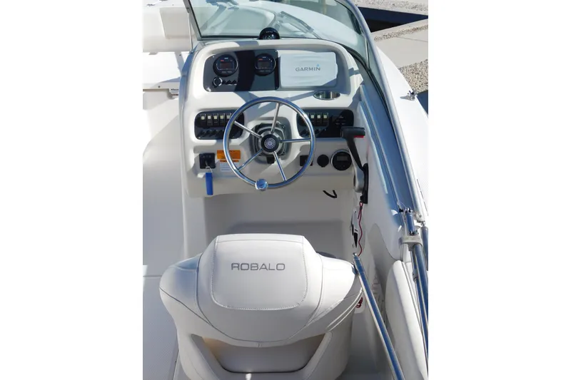 Slide: The Image of 2014 Robalo R207 Dual Console boat cockpit with steering wheel and Garmin display. - 12
