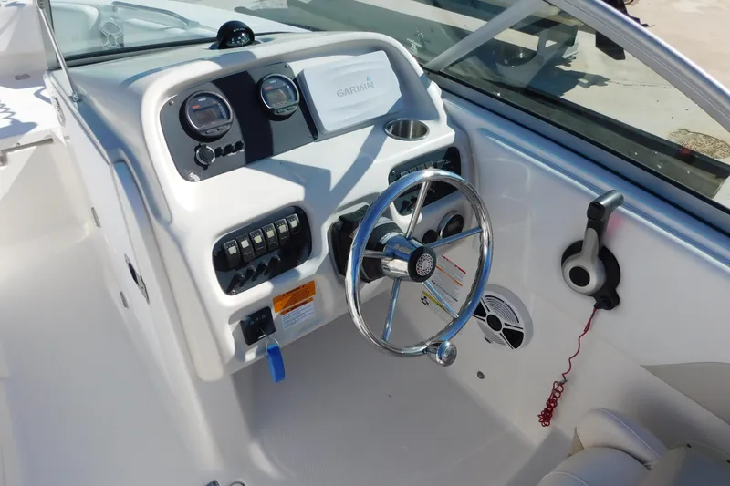 Slide: The Image of 2014 Robalo R207 Dual Console boat dashboard with steering wheel and controls. - 13