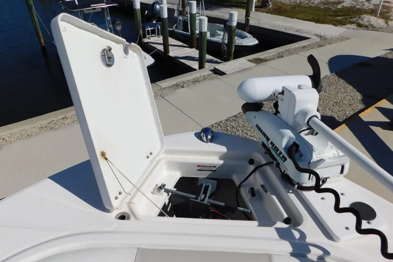 Slide: The Image of 2014 Robalo R207 Dual Console with open storage compartment and trolling motor at dock. - 24