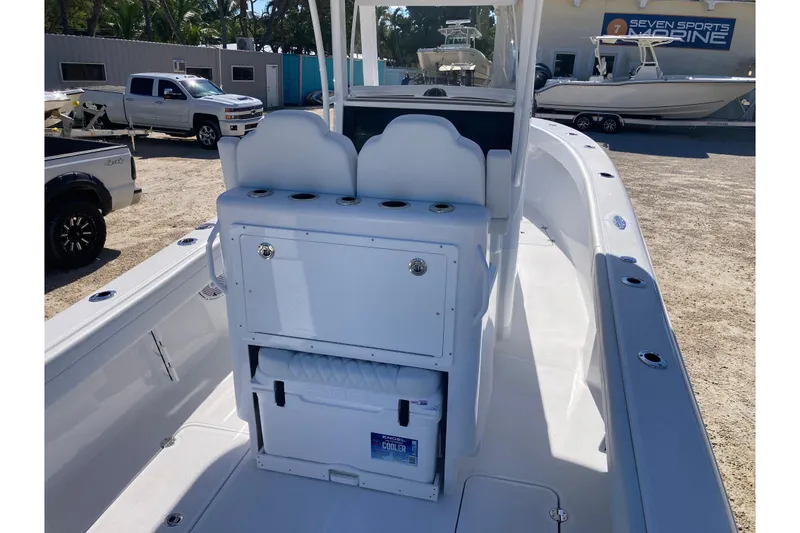 Slide: The Image of 2026 Bluewater 25 T boat interior with seating and storage, parked at a marine dealership. - 4