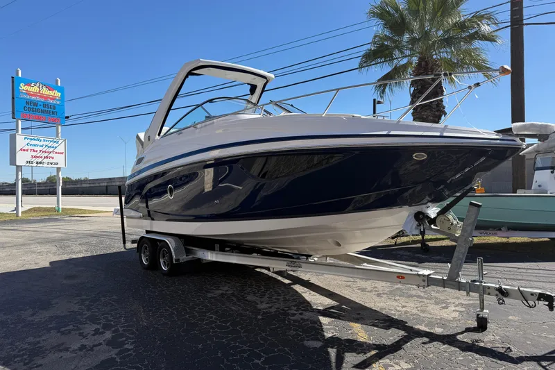The Image of 2026 Regal 28 Express boat on trailer at dealership, sunny day. - 0