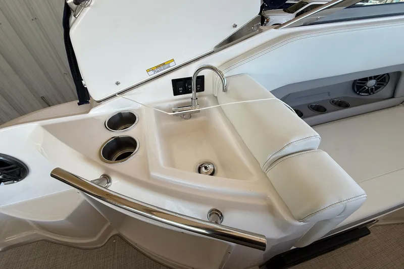 Slide: The Image of 2026 Regal 28 Express boat interior with sink, cup holders, and seating area. - 17