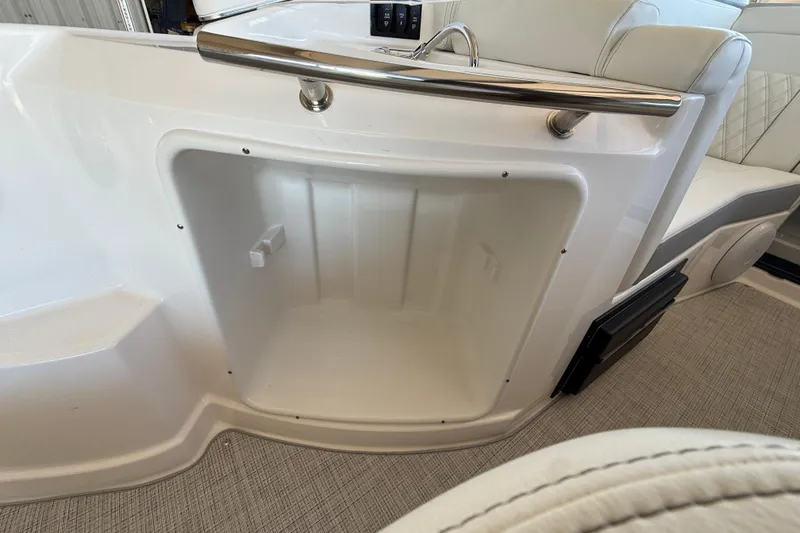 Slide: The Image of 2026 Regal 28 Express boat interior storage compartment with sleek white finish. - 19