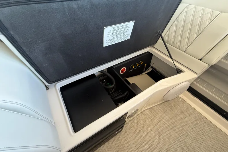 Slide: The Image of Open storage compartment in 2026 Regal 28 Express boat interior, featuring control panel and seating. - 22