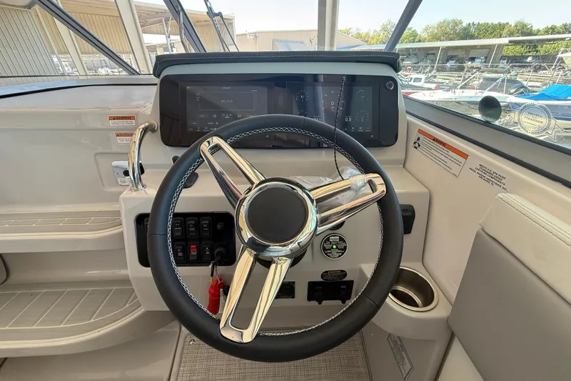 Slide: The Image of 2026 Regal 28 Express boat helm with modern steering wheel and control panel. - 26