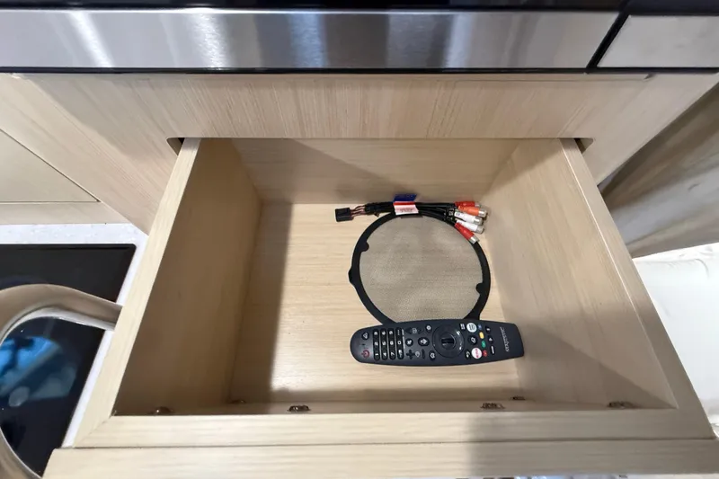 Slide: The Image of Open drawer with remote and cables in a 2026 Regal 28 Express boat. - 46