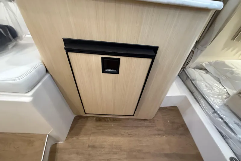 Slide: The Image of 2026 Regal 28 Express interior with compact wooden cabinet and integrated fridge. - 48