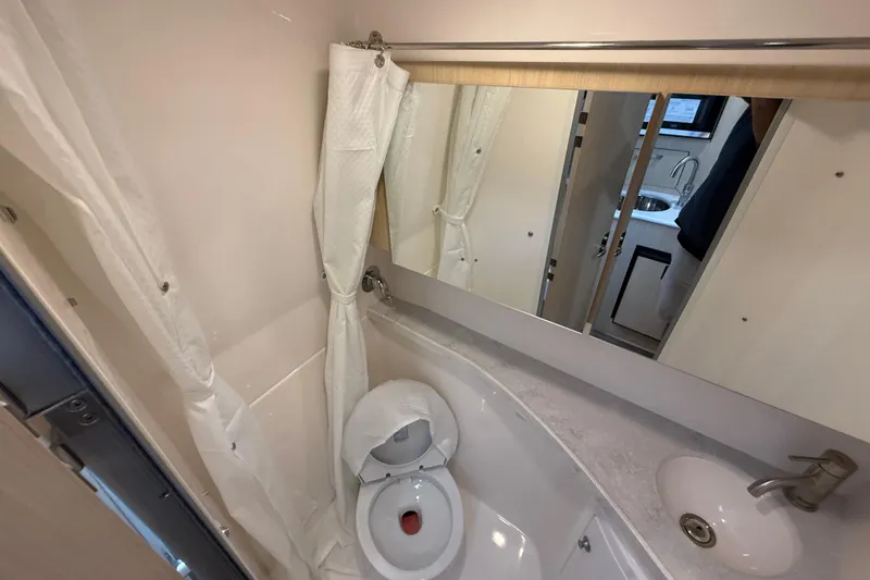 Slide: The Image of 2026 Regal 28 Express boat bathroom with toilet, sink, and mirror. - 52