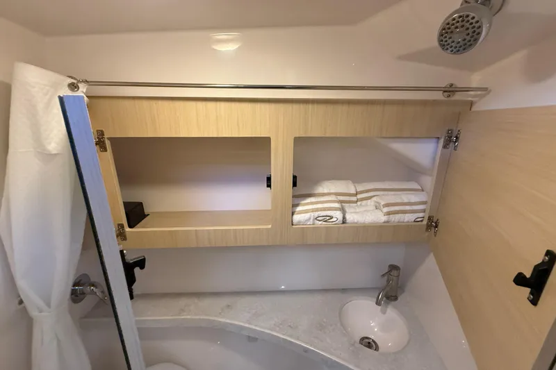 Slide: The Image of 2026 Regal 28 Express bathroom with wooden cabinets, sink, and showerhead. - 54