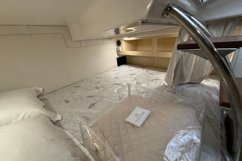 Slide: The Image of Cozy cabin interior of 2026 Regal 28 Express boat with bedding and storage. - 56