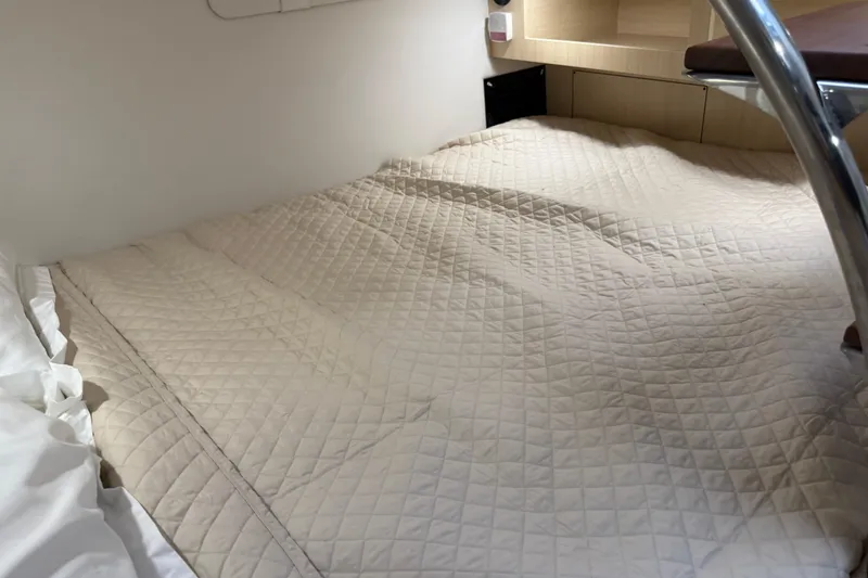 Slide: The Image of Cozy cabin bed in 2026 Regal 28 Express boat, featuring quilted bedding. - 59