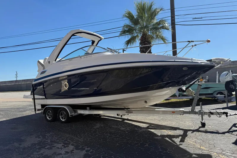 Slide: The Image of 2026 Regal 28 Express boat on trailer, parked outdoors under clear blue sky. - 60