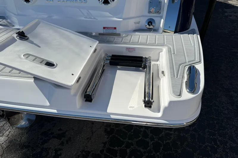 Slide: The Image of 2026 Regal 28 Express boat swim platform with foldable ladder and storage compartment. - 9