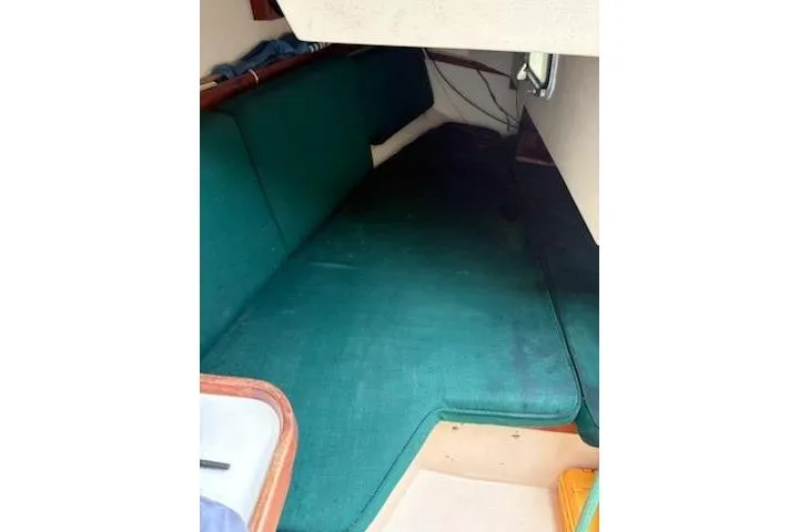 Slide: The Image of Interior cabin of a 1989 Catalina 30 sailboat with green cushions. - 12