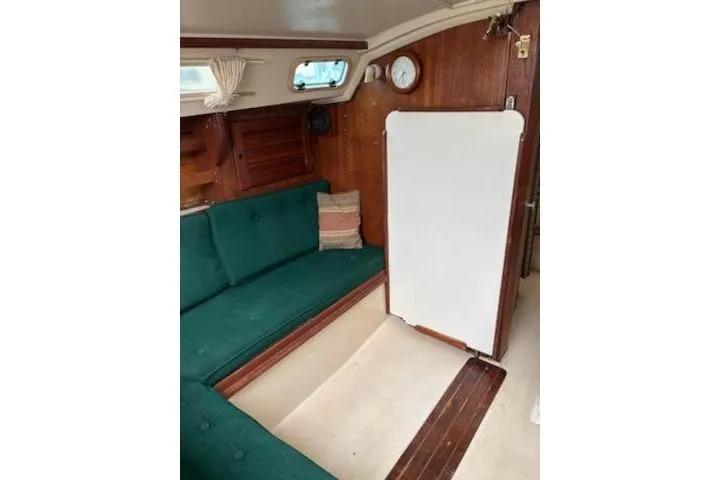 Slide: The Image of Interior of a 1989 Catalina 30 sailboat with green seating and wooden accents. - 6