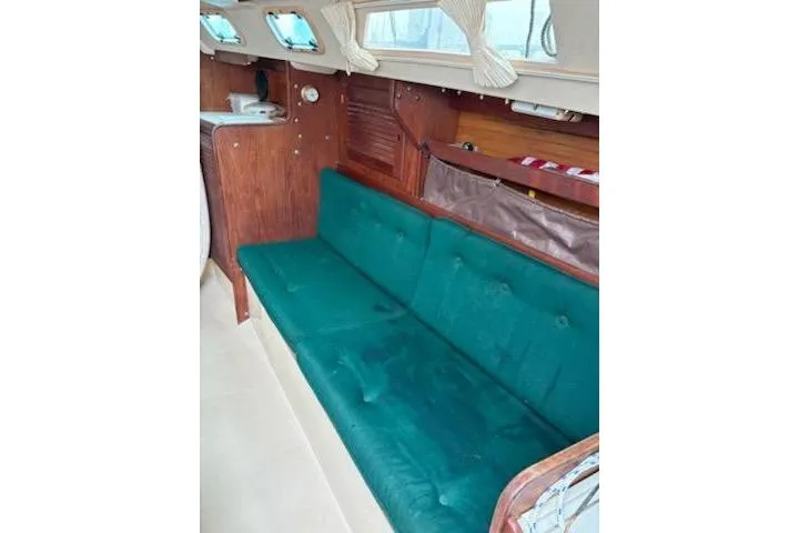 Slide: The Image of Interior of a 1989 Catalina 30 sailboat with green cushioned seating. - 7