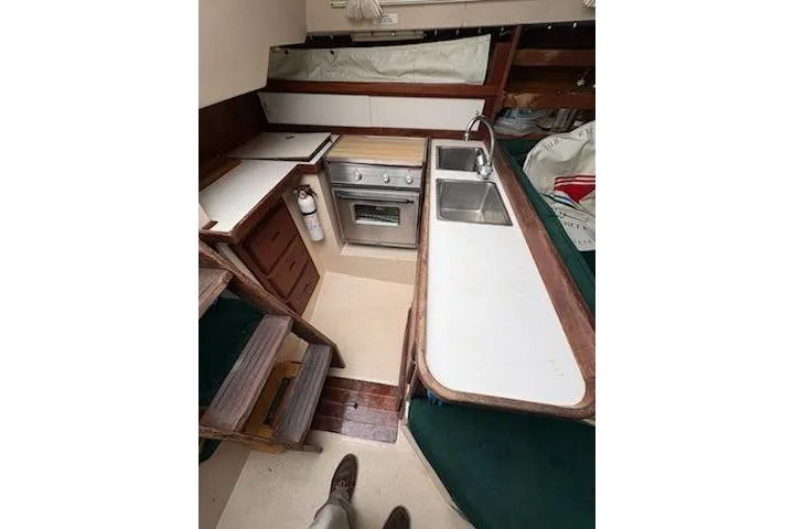Slide: The Image of Interior of 1989 Catalina 30 sailboat featuring compact kitchen with stove and sink. - 8