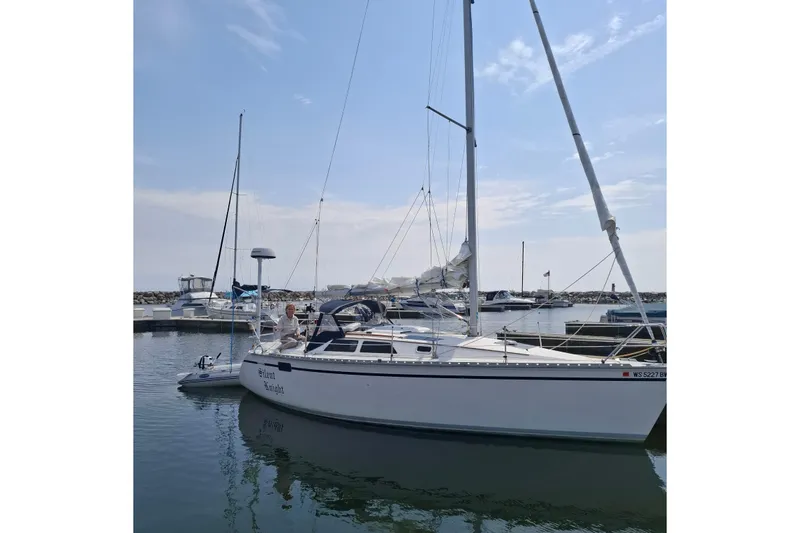 The Image of 1989 Hunter 30 sailboat docked in a marina under a clear blue sky. - 0