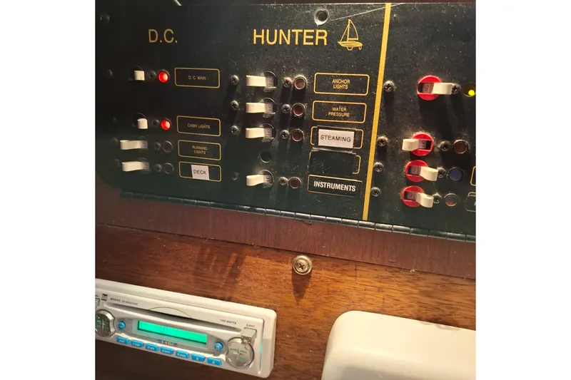 Slide: The Image of Control panel of a 1989 Hunter 30 sailboat with labeled switches and stereo system. - 14
