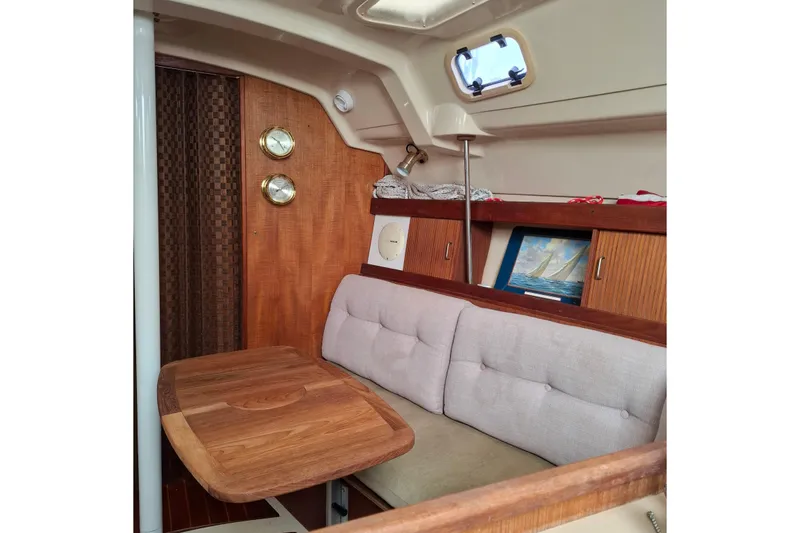 Slide: The Image of Interior of a 1989 Hunter 30 sailboat with wooden table and cushioned seating. - 15
