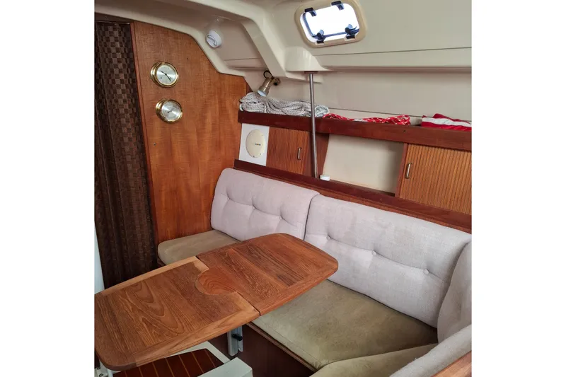 Slide: The Image of Cozy interior of 1989 Hunter 30 sailboat with wooden table and cushioned seating. - 16