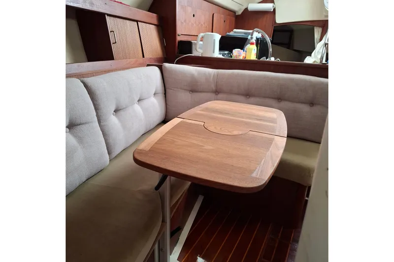 Slide: The Image of Cozy interior of 1989 Hunter 30 sailboat with wooden table and cushioned seating. - 18