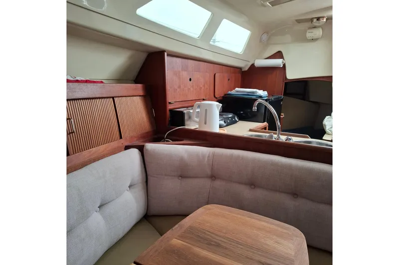 Slide: The Image of Interior of 1989 Hunter 30 sailboat with cozy seating and wooden cabinetry. - 19