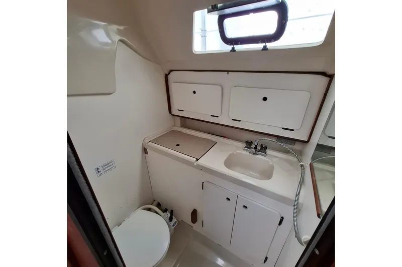 Slide: The Image of Interior of 1989 Hunter 30 sailboat bathroom with sink, toilet, and storage cabinets. - 21