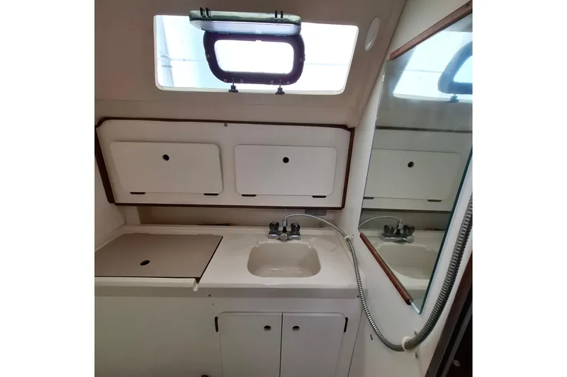 Slide: The Image of Compact bathroom in 1989 Hunter 30 sailboat with sink, mirror, and storage cabinets. - 22