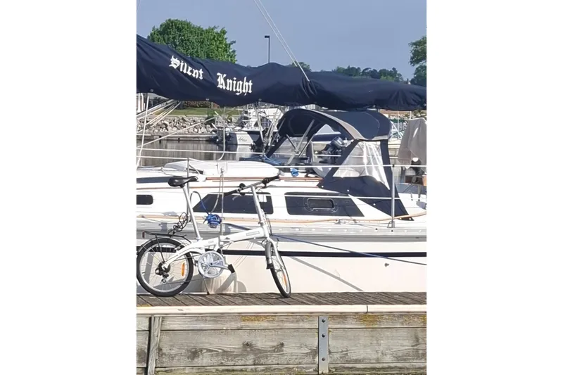 Slide: The Image of 1989 Hunter 30 sailboat "Silent Knight" docked with a folding bicycle nearby. - 3