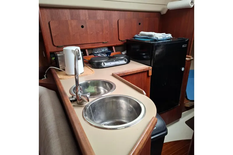 Slide: The Image of Compact galley kitchen in 1989 Hunter 30 sailboat with sink, mini fridge, and appliances. - 8