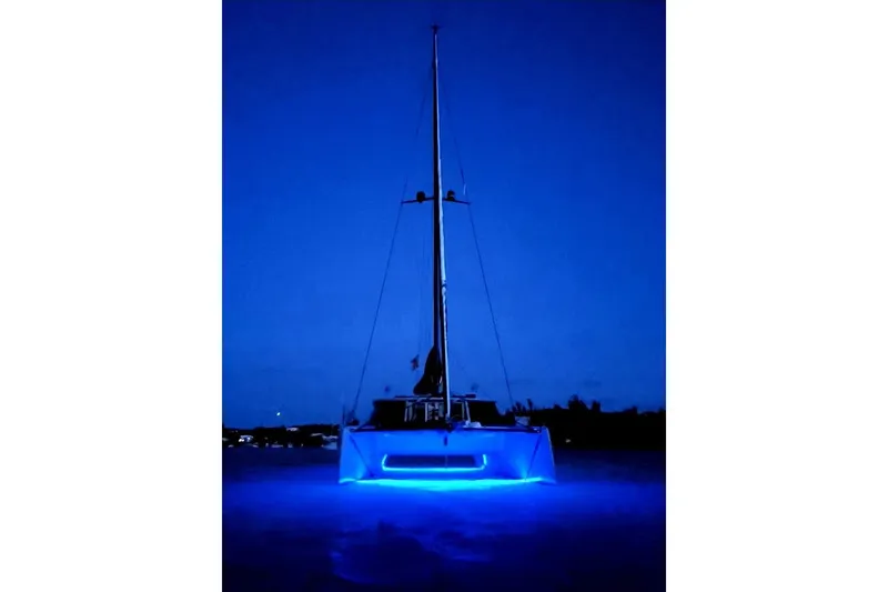 Slide: The Image of 2017 Harvey Yachts 58 illuminated with blue lights at night. - 112