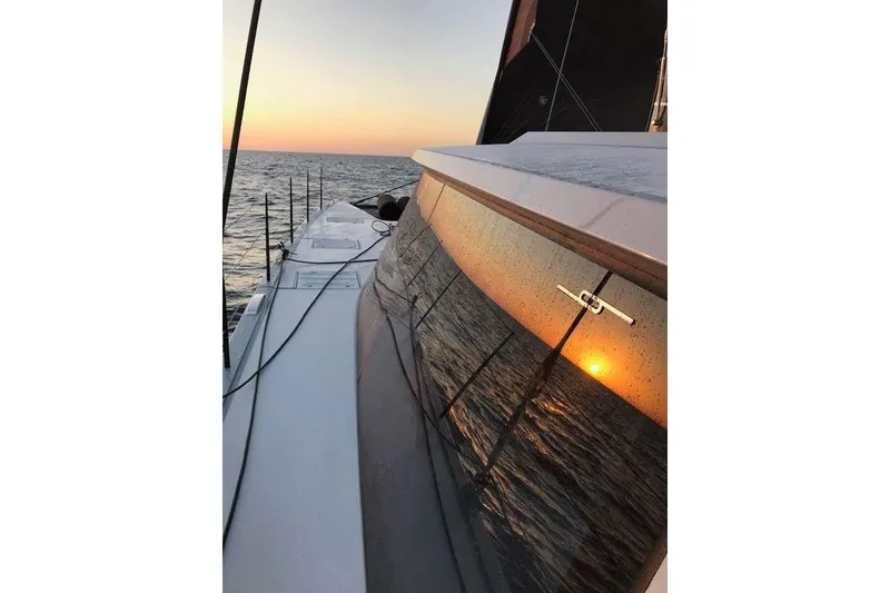 Slide: The Image of 2017 Harvey Yachts 58 sailing at sunset, reflecting ocean and sun on windows. - 114
