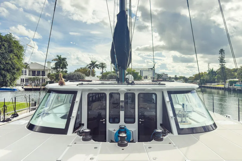 Slide: The Image of 2017 Harvey Yachts 58 docked, showcasing sleek design and spacious deck under a cloudy sky. - 13