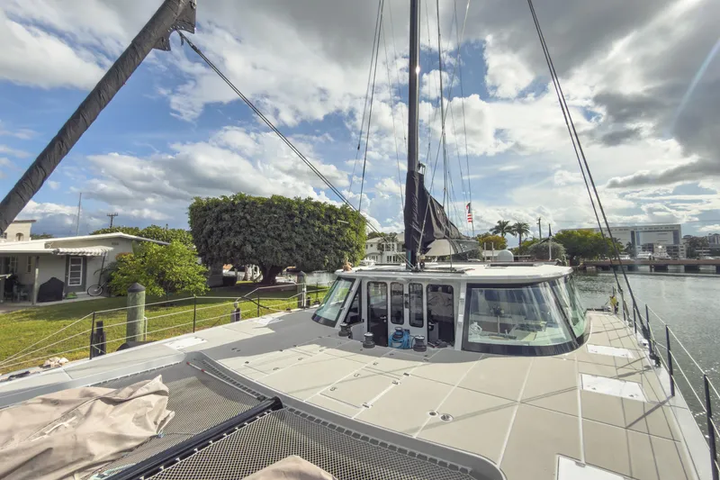 Slide: The Image of 2017 Harvey Yachts 58 docked, showcasing sleek design and spacious deck under a partly cloudy sky. - 15