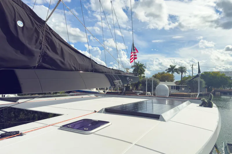 Slide: The Image of 2017 Harvey Yachts 58 sailboat with solar panel, docked under a partly cloudy sky. - 18