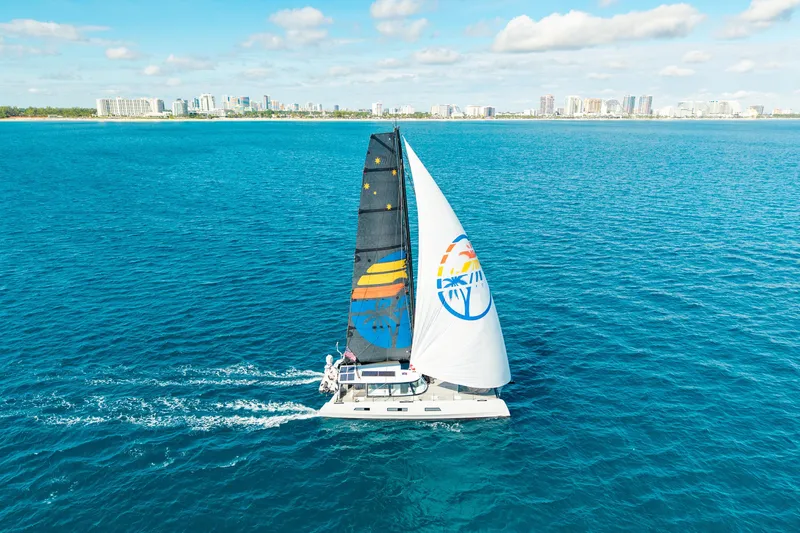 Slide: The Image of Sailing yacht Harvey Yachts 58, 2017 model, cruising on clear blue ocean near city skyline. - 2