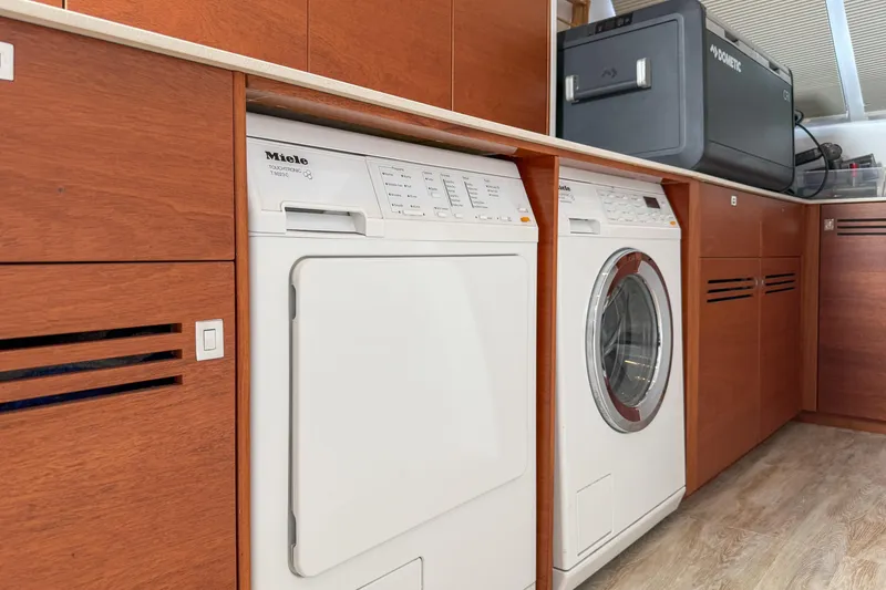 Slide: The Image of Laundry area on a 2017 Harvey Yachts 58, featuring Miele appliances and wooden cabinetry. - 57
