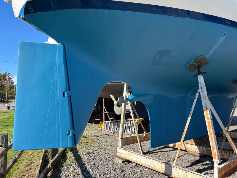 Slide: The Image of 1979 Hallberg-Rassy 38 sailboat hull on stands, showcasing rudder and propeller. - 11