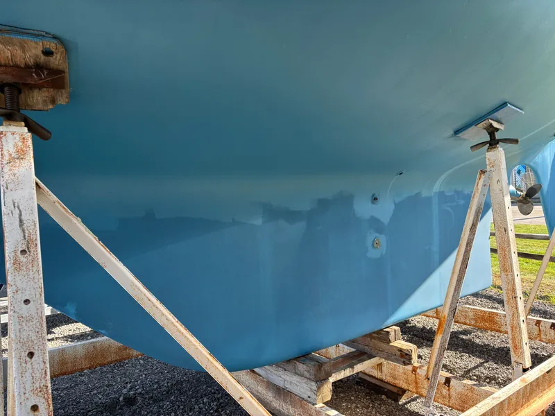 Slide: The Image of 1979 Hallberg-Rassy 38 sailboat hull on stands, undergoing maintenance. - 15